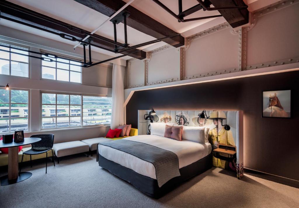 シドニーにあるオヴォロ ウールムールーの大きなベッドとソファが備わるホテルルームです。
