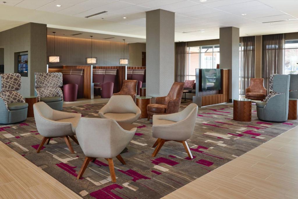 a waiting room with chairs and a tv in a lobby at Courtyard by Marriott Rome in Rome
