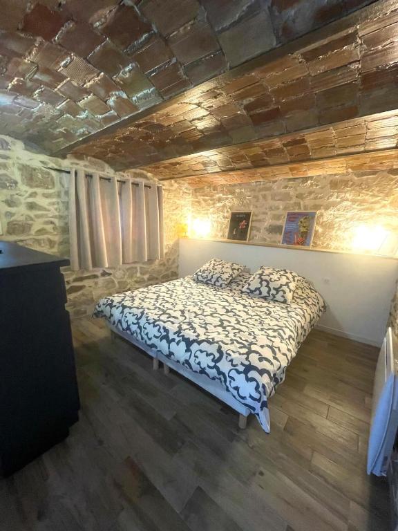 une chambre avec un lit dans un mur de pierre dans l'établissement Appartement T3 Nîmes Centre, à Nîmes