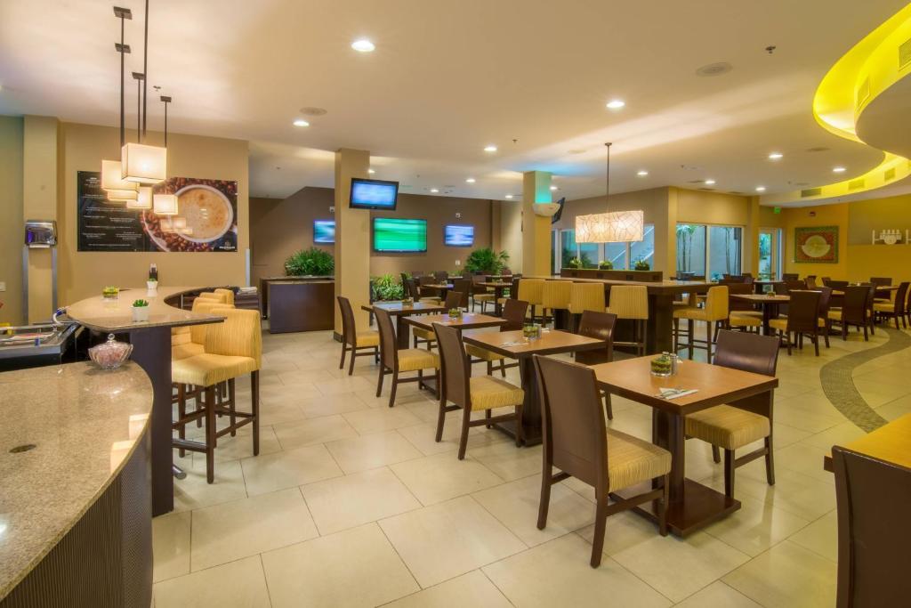 a dining room with tables and chairs in a restaurant at Courtyard by Marriott San Jose Airport Alajuela in Alajuela City