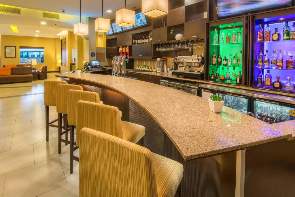 a bar in a restaurant with chairs and a counter at Courtyard by Marriott San Jose Airport Alajuela in Alajuela City