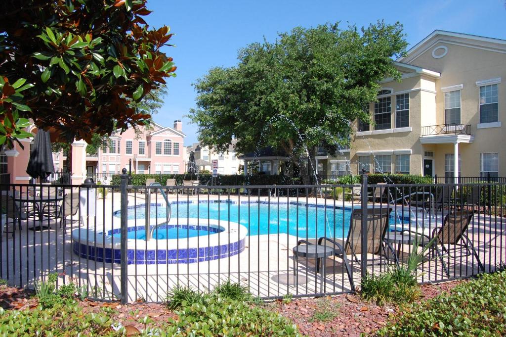 a swimming pool with chairs and a fence at Legacy Villa 304 in Gulfport