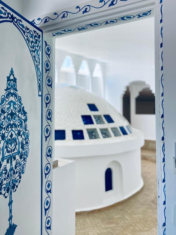 a mirror in a room with a blue and white object at Hotel Al Alba Hammam & Restaurant in Asilah