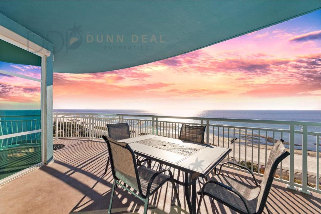 a table and chairs on a balcony with the ocean at Legacy Tower I 903 in Gulfport