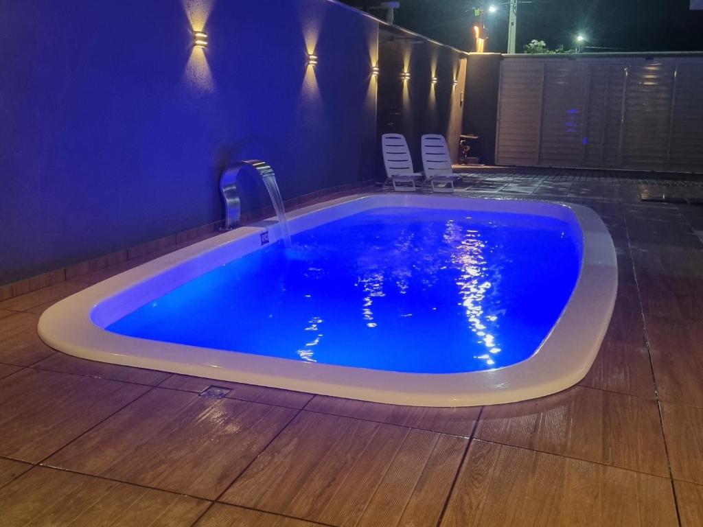 a large blue swimming pool with chairs around it at Flat Praia Dourada 5 in Maragogi