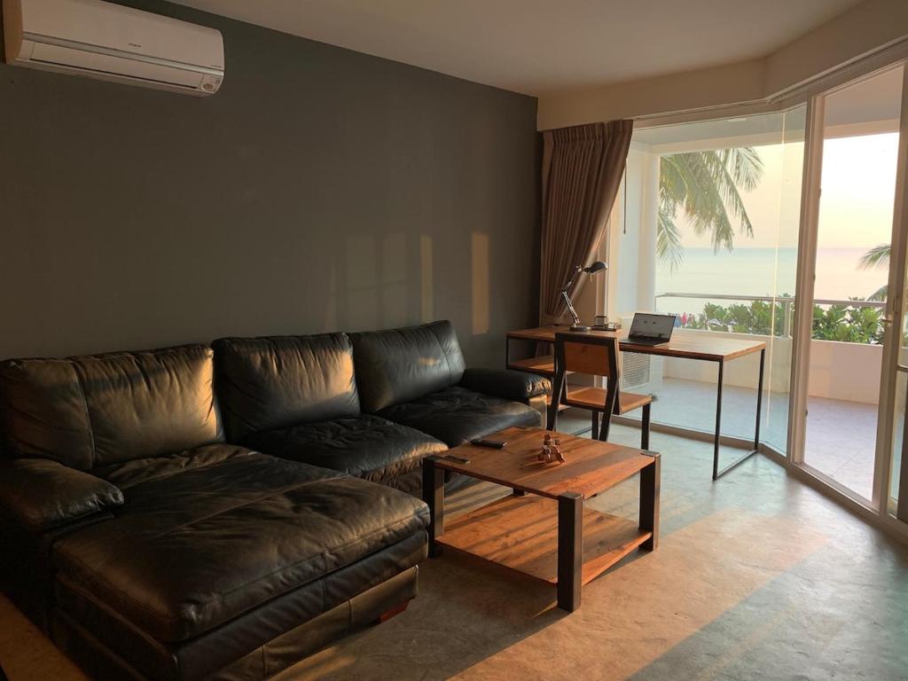 a living room with a leather couch and a table at 2 Bedder Beach Front Condo in Prime Location in Hua Hin