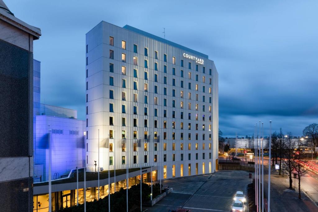 un edificio blanco alto con luces encendidas en Courtyard Tampere City, en Tampere