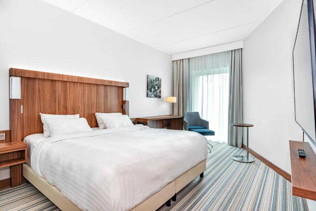 um quarto de hotel com uma cama grande e uma televisão em Courtyard Tampere City em Tampere