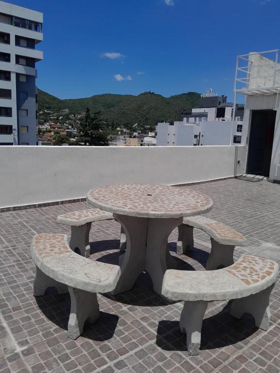 a picnic table and two benches on a roof at Abuela Betty in Villa Carlos Paz