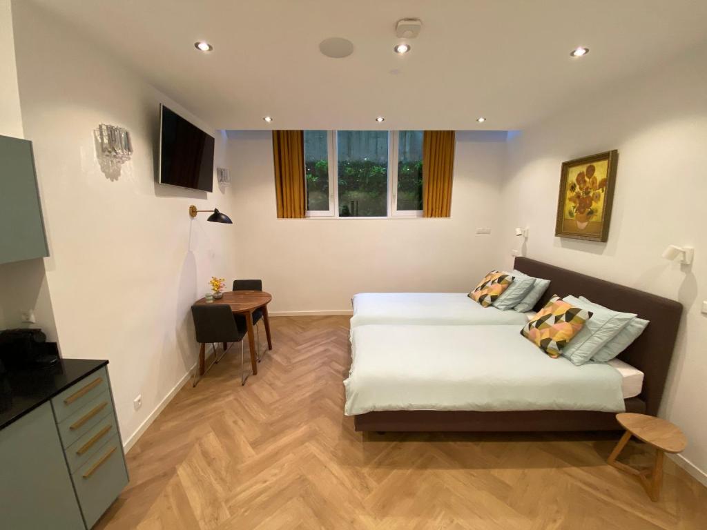 Hotel Goodnight Amsterdam Lovely B&B in city centre-private-quiet-luxurious, a bedroom with two beds and a table in it at Goodnight Amsterdam Lovely B&B in city centre-private-quiet-luxurious in Amsterdam