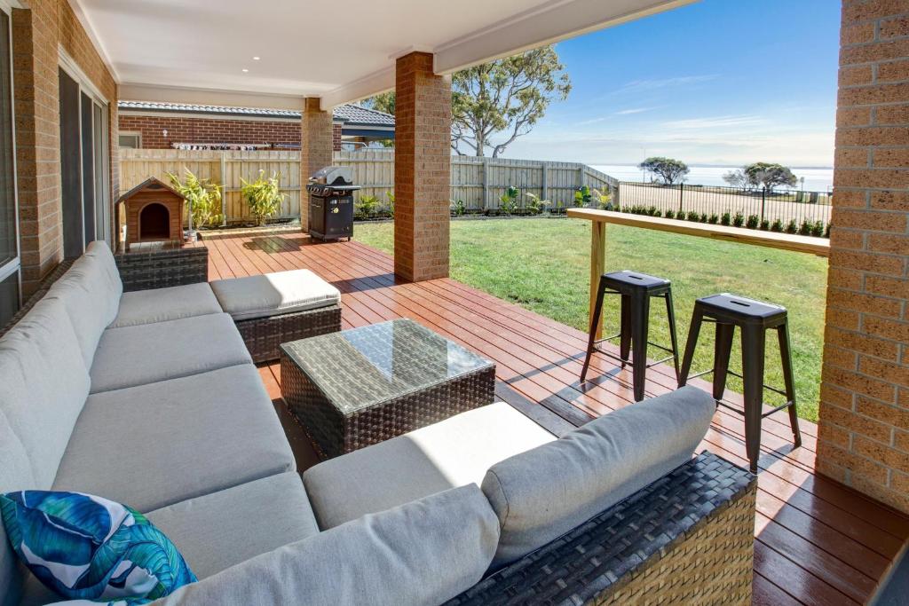 eine Terrasse mit einem Sofa und 2 Hockern in der Unterkunft Captains Hideaway in Paynesville