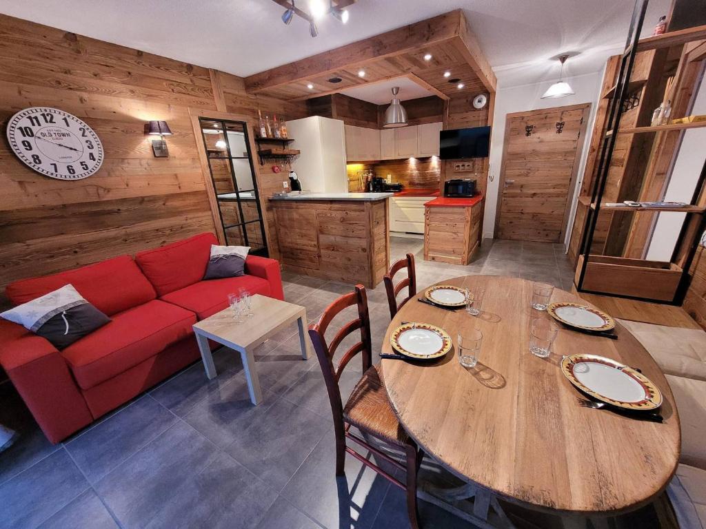 un salon avec un canapé rouge et une table en bois dans l'établissement Appartement cosy aux Gets, balcon et parking au centre - FR-1-598-184, aux Gets