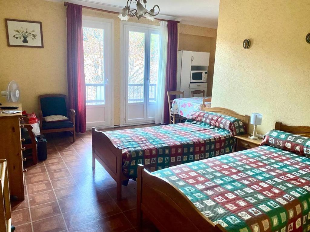 une chambre d'hôtel avec deux lits et une fenêtre dans l'établissement Studio aux Thermes avec Parking et WIFI - FR-1-703-199, à Amélie-les-Bains-Palalda