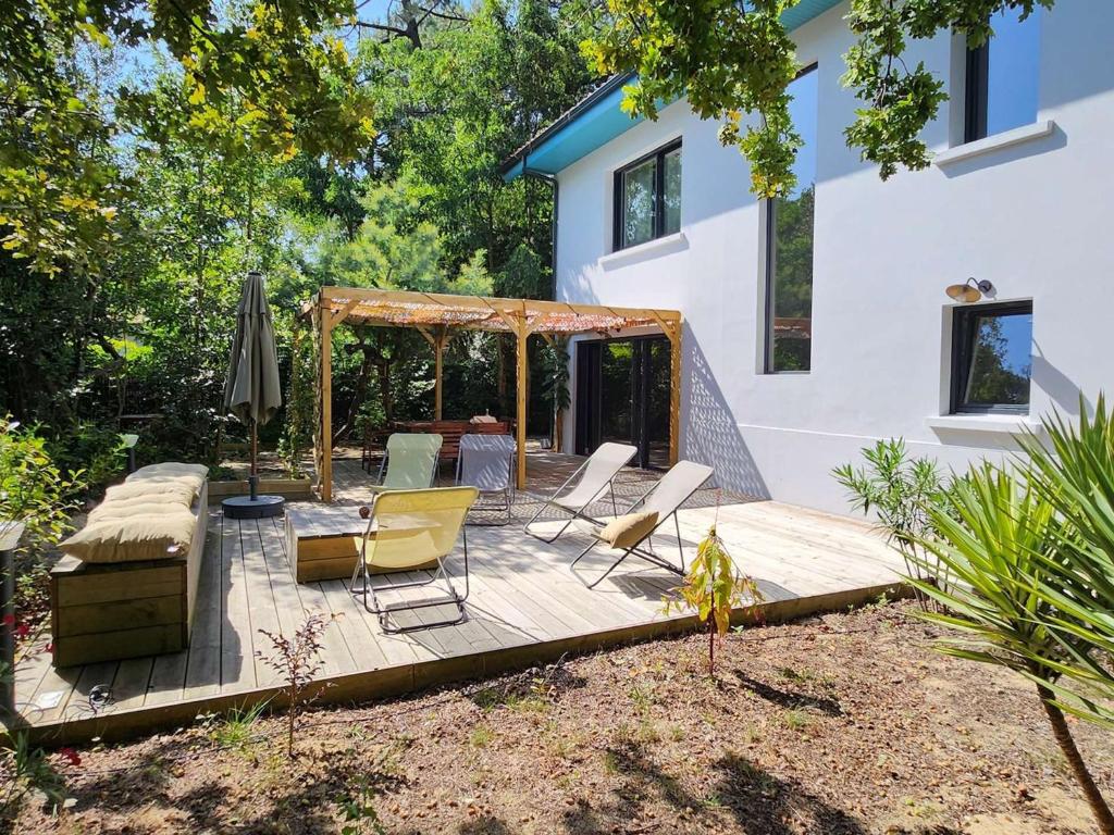 une terrasse en bois avec des chaises et un kiosque dans l'établissement Villa 6 ch. avec sauna, jardin et parking près du Bassin d'Arcachon - FR-1-736-51, à Lège-Cap-Ferret