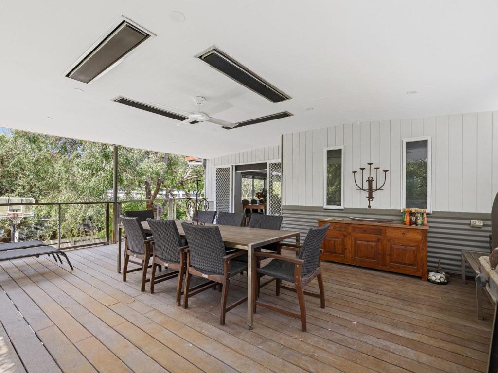 comedor con mesa y sillas en la terraza en Beachside Family Haven, en Inverloch