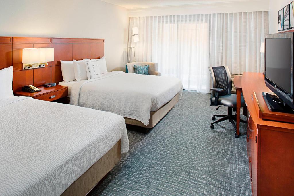 a hotel room with two beds and a desk and a television at Courtyard by Marriott Tucson Williams Centre in Tucson