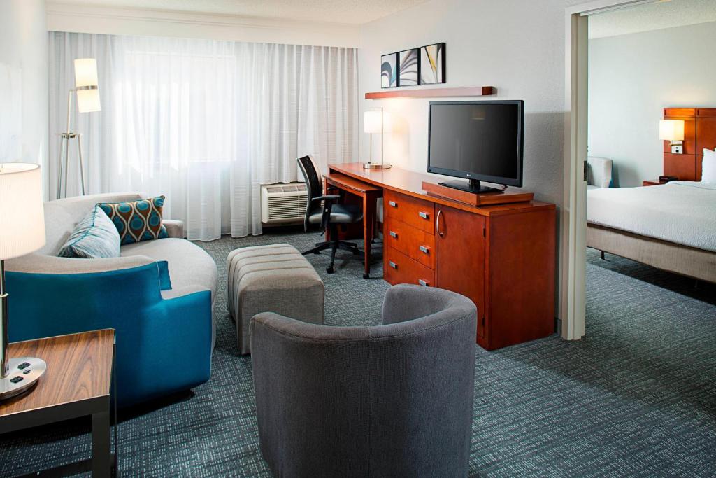 a hotel room with a bed and a desk with a television at Courtyard by Marriott Tucson Williams Centre in Tucson