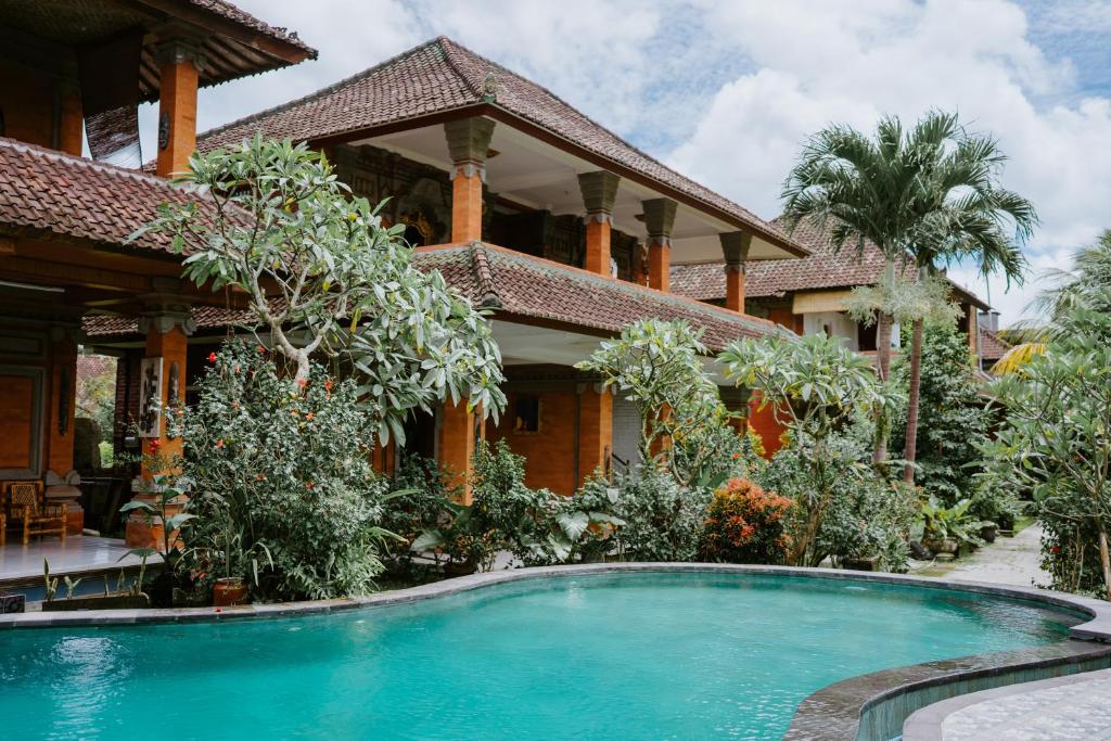 a house with a swimming pool in front of it at Warsi Bungalow in Ubud