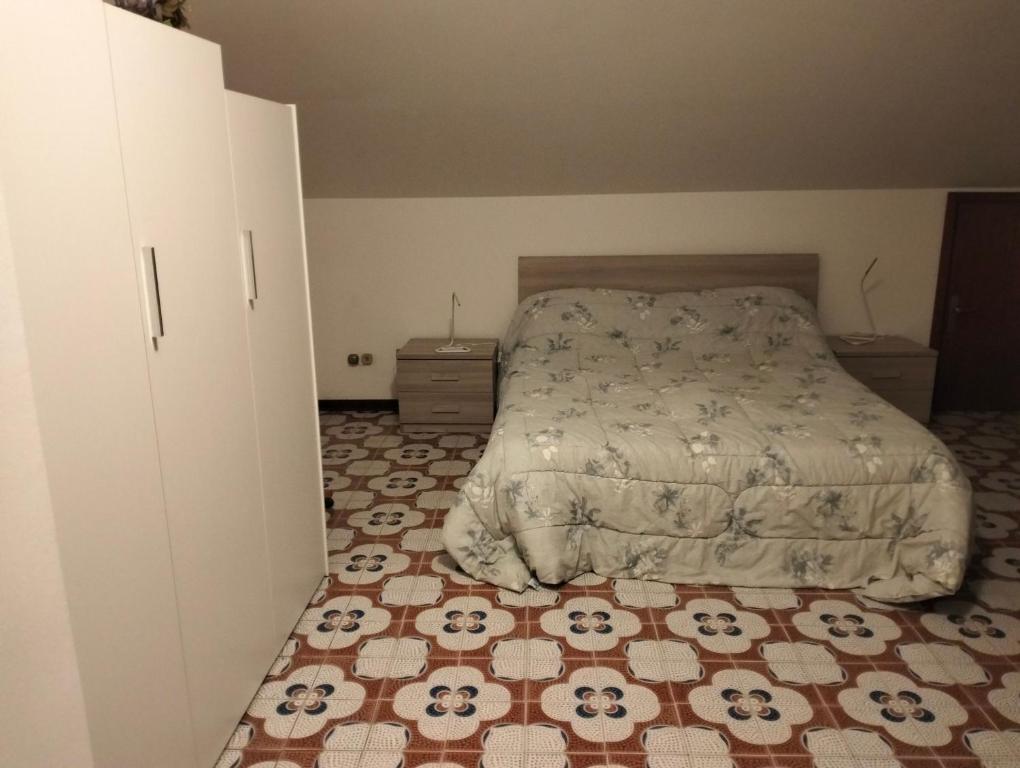 a bedroom with a bed and a tiled floor at Esperia in Caorle