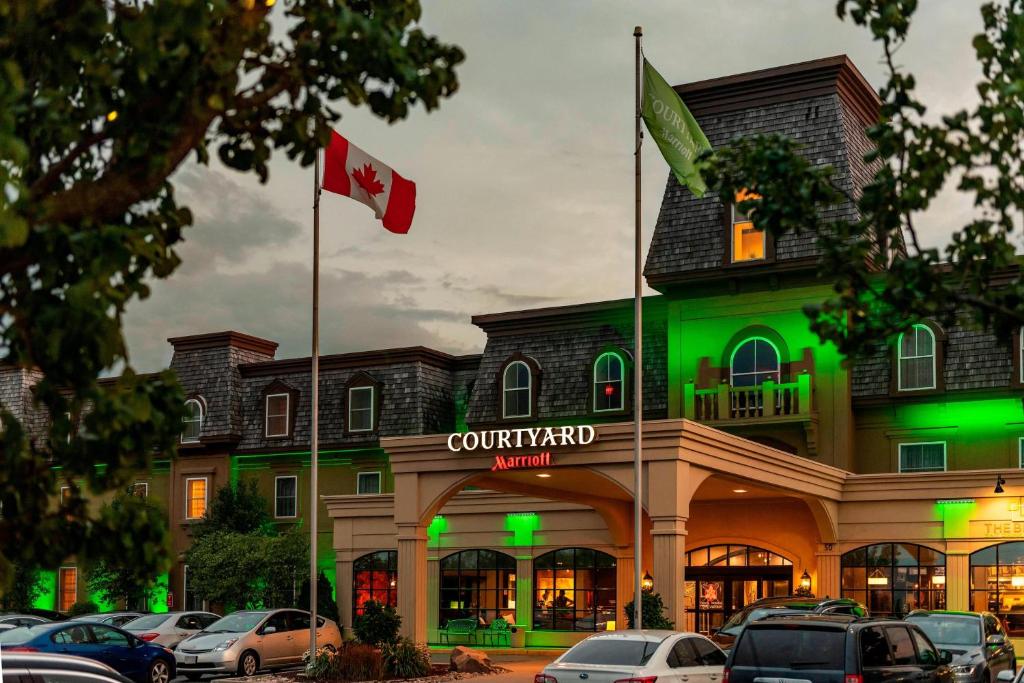 un edificio con dos banderas canadienses delante de él en Courtyard by Marriott Waterloo St. Jacobs, en Waterloo