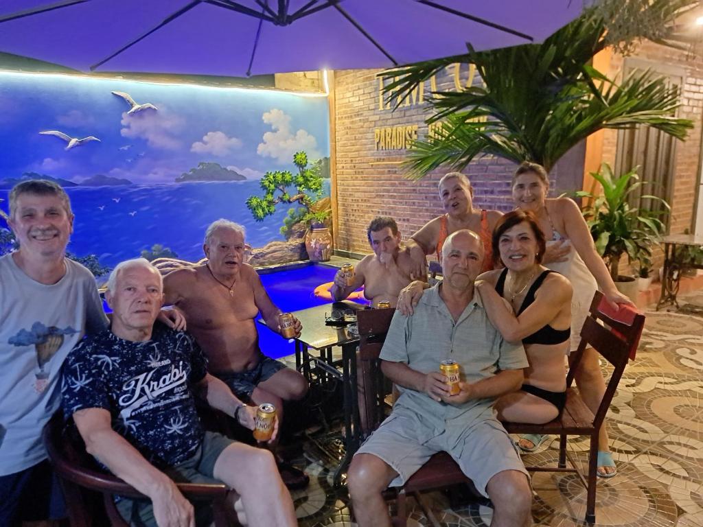 a group of people sitting in chairs under an umbrella at Tam Coc Paradise Homestay in Ninh Binh