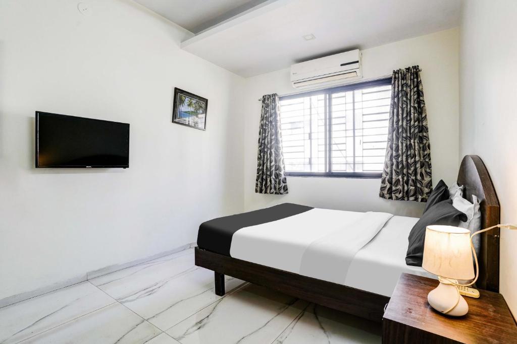 Postel nebo postele na pokoji v ubytování Hotel O Nashik Near Vijay Mamta Theatre Formerly Sahara Inn