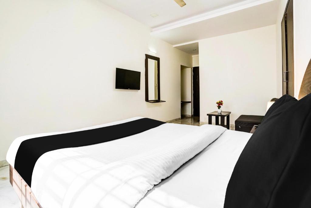 Postel nebo postele na pokoji v ubytování Hotel O Nashik Near Vijay Mamta Theatre Formerly Sahara Inn