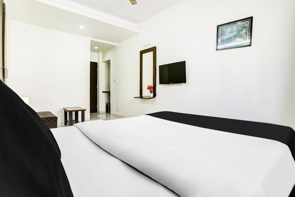 Postel nebo postele na pokoji v ubytování Hotel O Nashik Near Vijay Mamta Theatre Formerly Sahara Inn