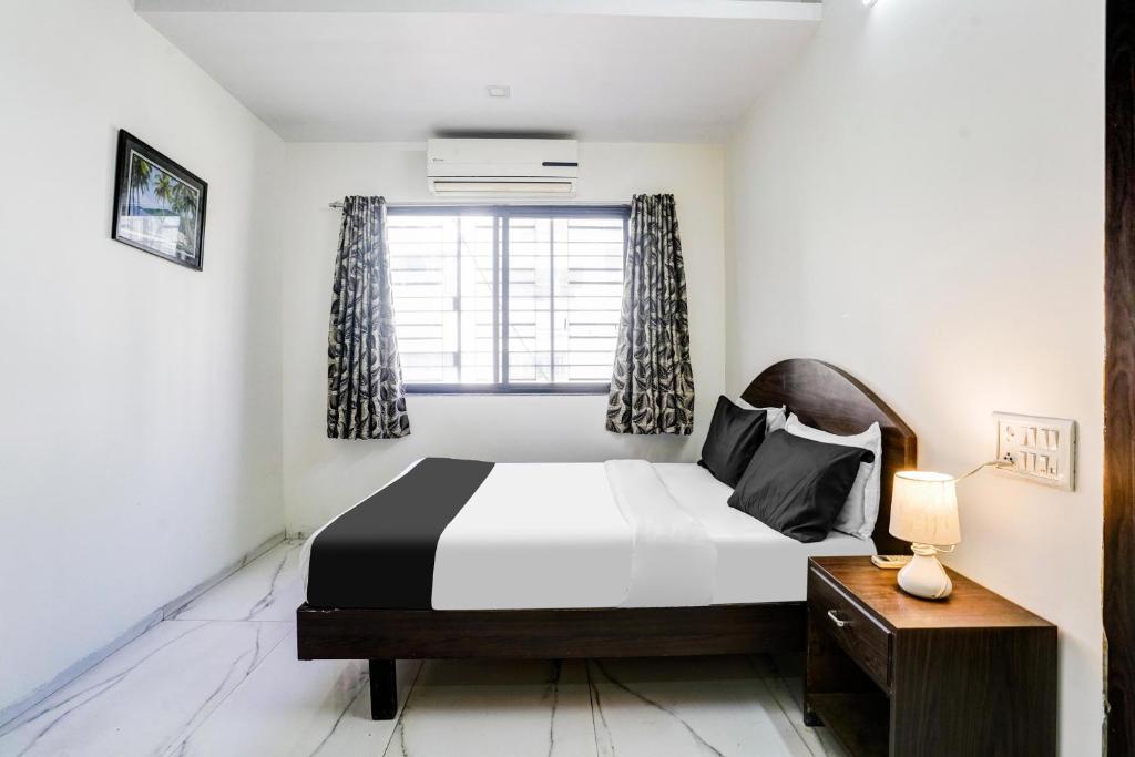 Postel nebo postele na pokoji v ubytování Hotel O Nashik Near Vijay Mamta Theatre Formerly Sahara Inn