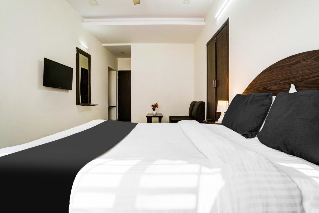 Postel nebo postele na pokoji v ubytování Hotel O Nashik Near Vijay Mamta Theatre Formerly Sahara Inn
