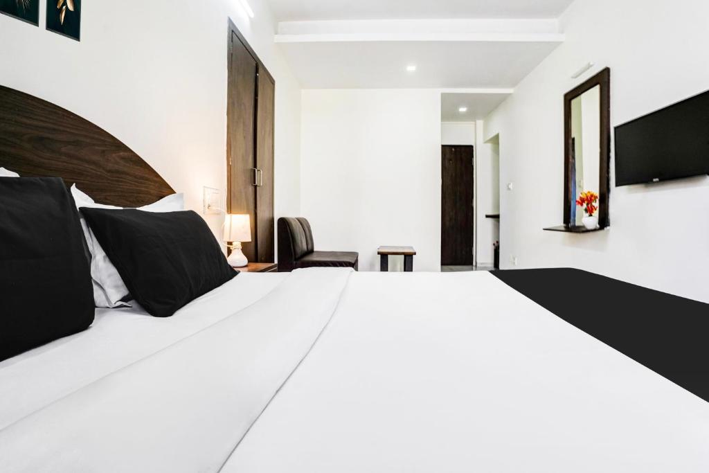 Postel nebo postele na pokoji v ubytování Hotel O Nashik Near Vijay Mamta Theatre Formerly Sahara Inn
