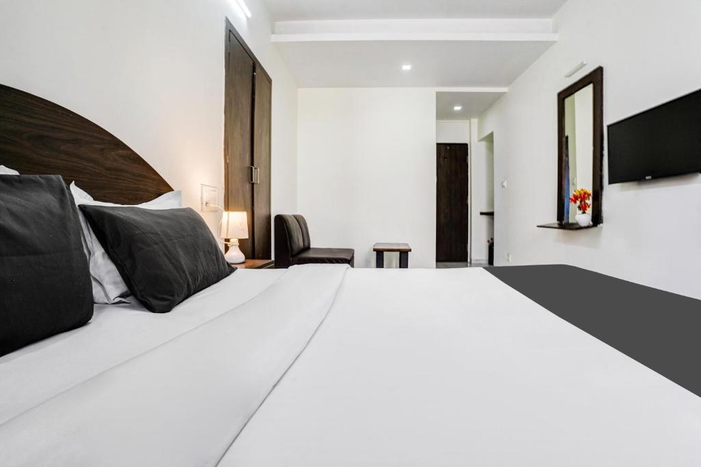 Postel nebo postele na pokoji v ubytování Hotel O Nashik Near Vijay Mamta Theatre Formerly Sahara Inn