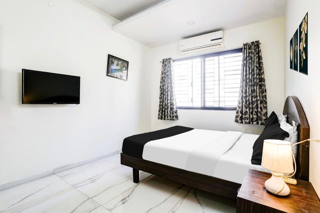 Postel nebo postele na pokoji v ubytování Hotel O Nashik Near Vijay Mamta Theatre Formerly Sahara Inn