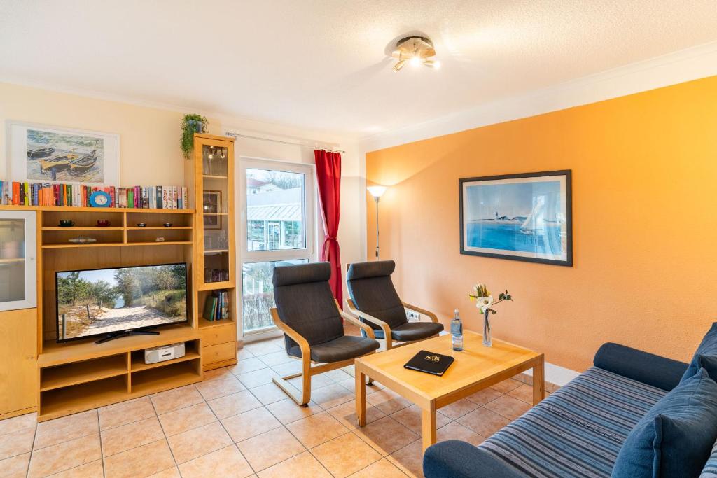 a living room with a couch and a tv at Düneneck 09 in Zempin