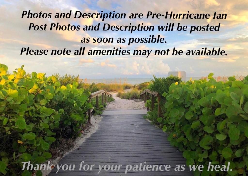 ein Bild von einem Holzweg mit Blumen in der Unterkunft Island Beach Club #220C in Sanibel