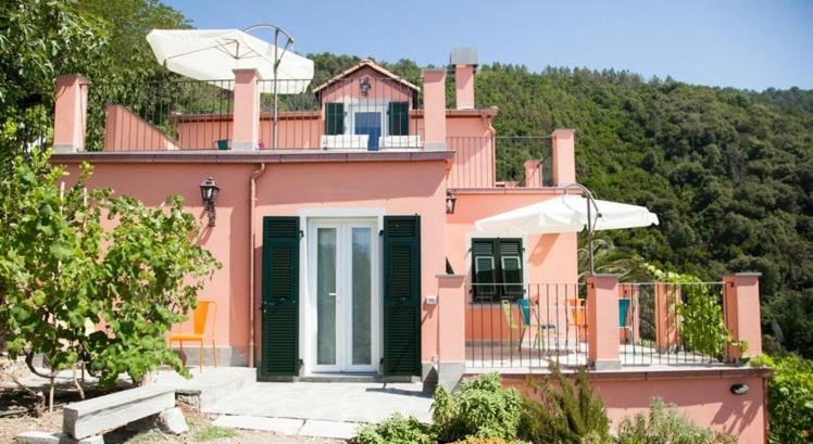 a pink house with a balcony with chairs on it at Il Nettare in Riomaggiore