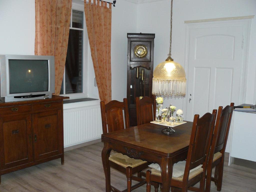 a dining room with a table and a tv at FeWo am Mu-Cafe in Emmerich