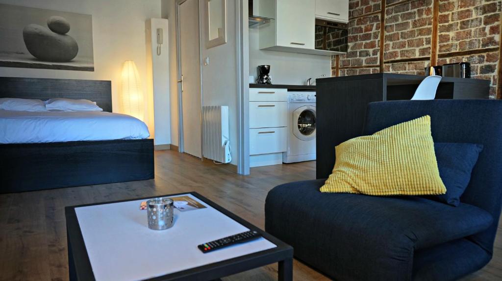 een woonkamer met een bed, een stoel en een salontafel bij Little Suite - Héloise in Lille