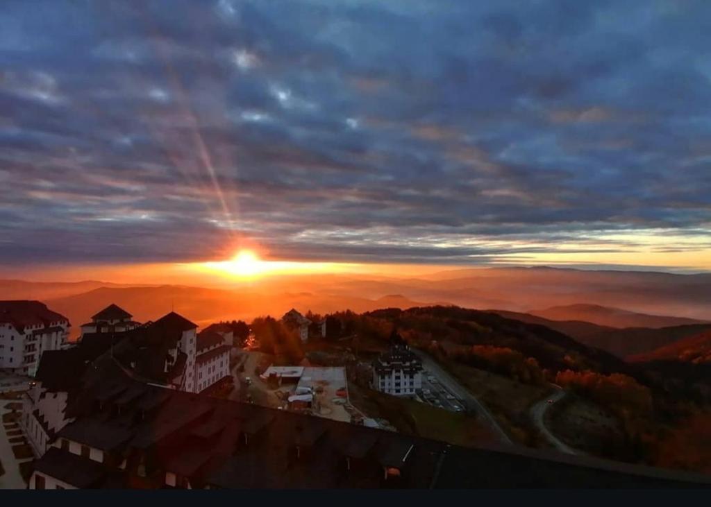 a sunset over a city with the sun in the sky at Vila Barselona Kopaonik in Raška