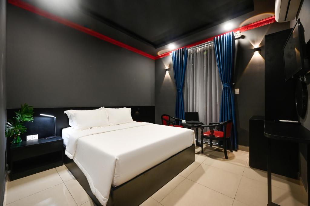 a bedroom with a white bed and a table at Trung Mai Hotel - Nguyễn Thái Bình in Ho Chi Minh City