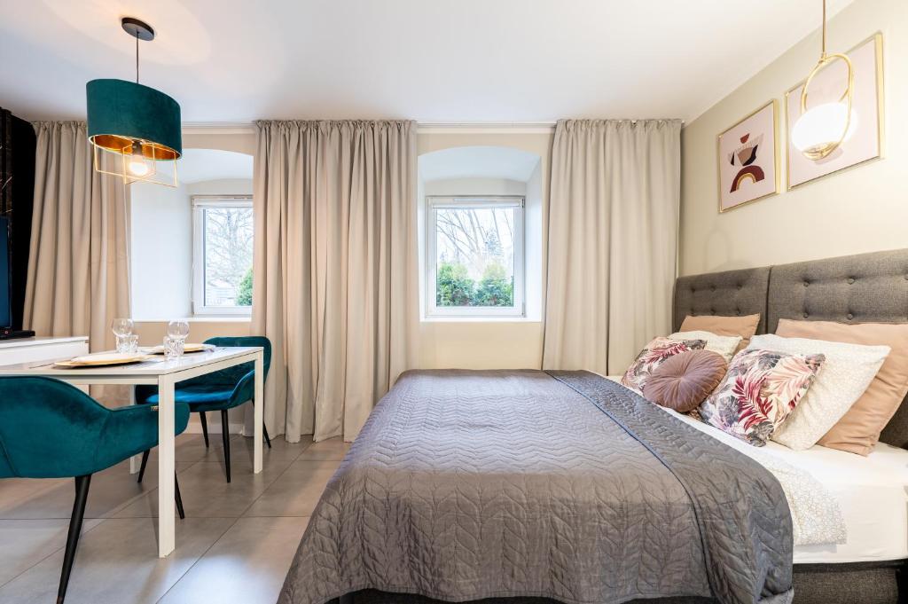sypialnia z łóżkiem, stołem i biurkiem w obiekcie 7apartments przy Termach Cieplickich w Jeleniej Górze
