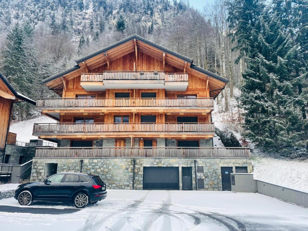 モントリオンにあるLe refuge de Montriondの雪の中の建物の前に停車する車