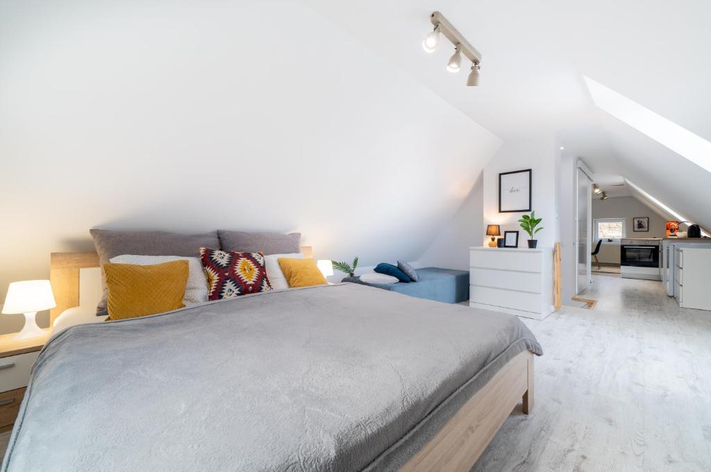 sypialnia z dużym łóżkiem i kuchnią w obiekcie 7apartments przy Termach Cieplickich w Jeleniej Górze