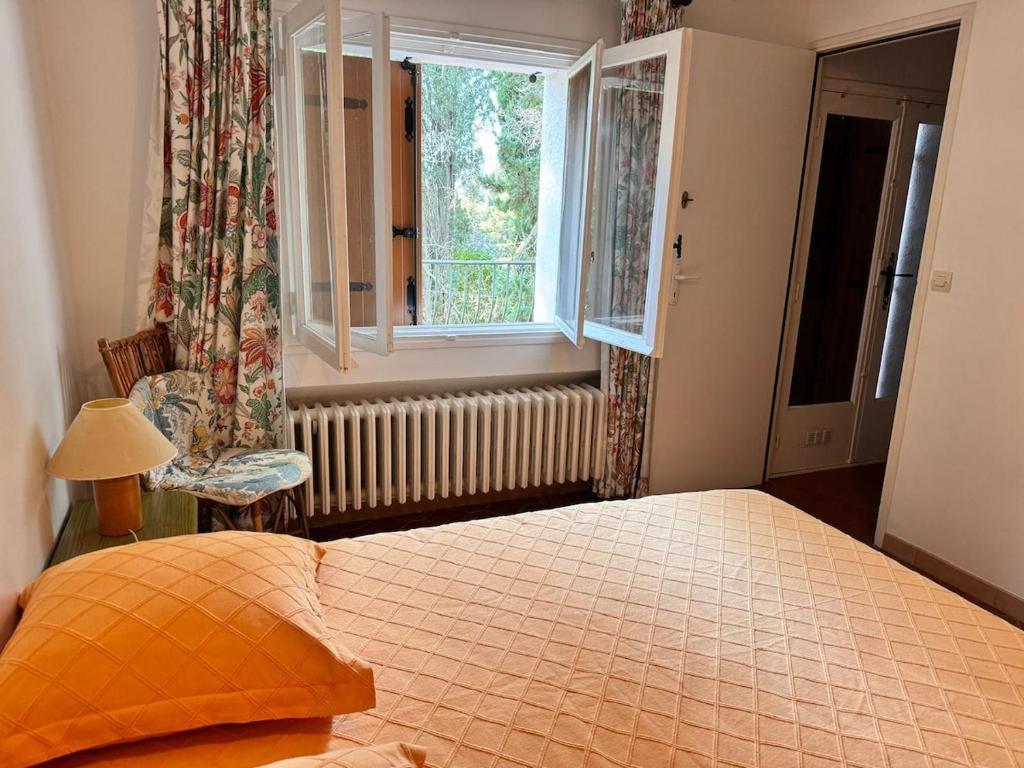 une chambre avec un grand lit et une fenêtre dans l'établissement La Ferme, agréable gîte en pleine nature, à Hyères