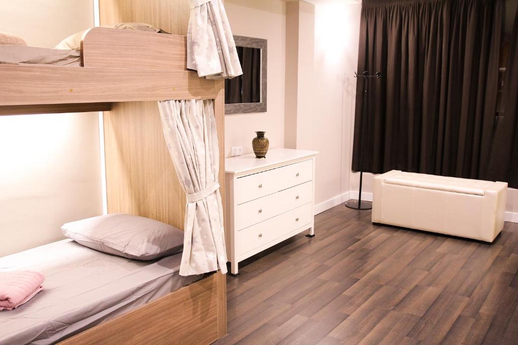 a bedroom with a bunk bed and a dresser at Barcelona & You Hostel Sagrada Familia in Barcelona