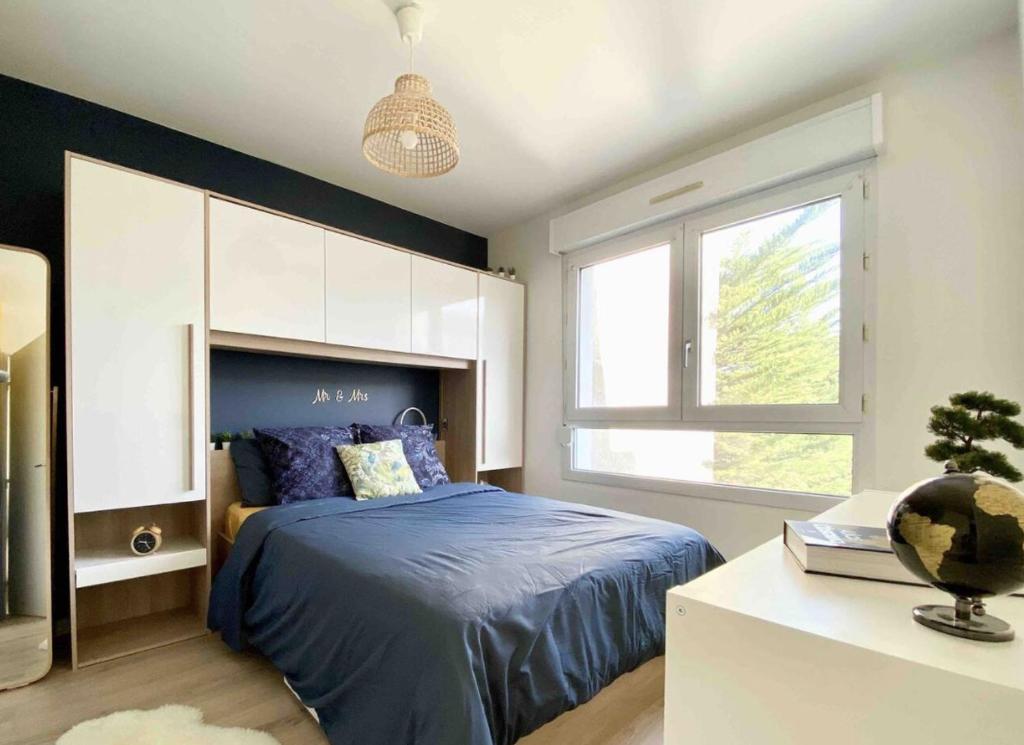 une chambre avec un lit bleu et une fenêtre dans l'établissement Cocon Elephant, à Nantes