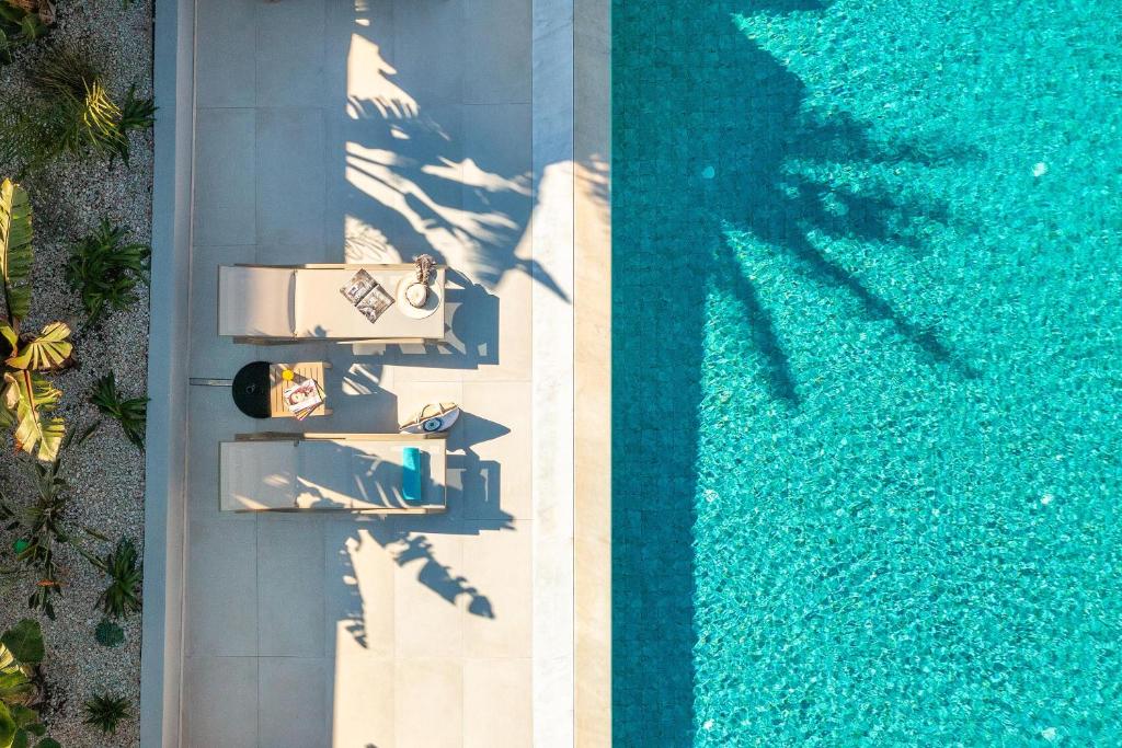 an overhead view of a swimming pool with two people at Elias' Rest Villa in Pastida