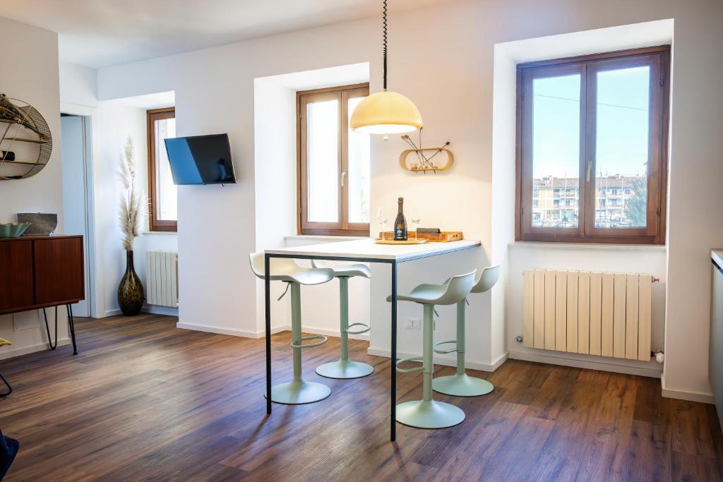 a kitchen with a table and stools in a room at Villa Denis - Stylisches Premium Altstadt-Apartment mit Hafenblick & 2 Bädern in Grado