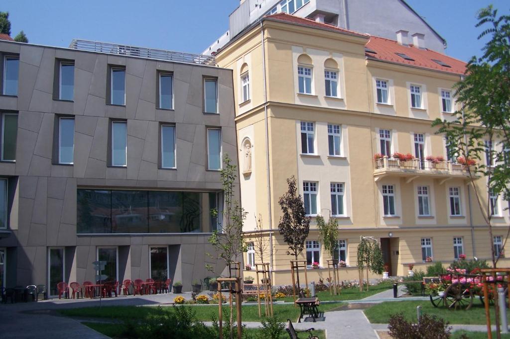 un grande edificio con tavoli e sedie di fronte di Centrum Salvator a Bratislava