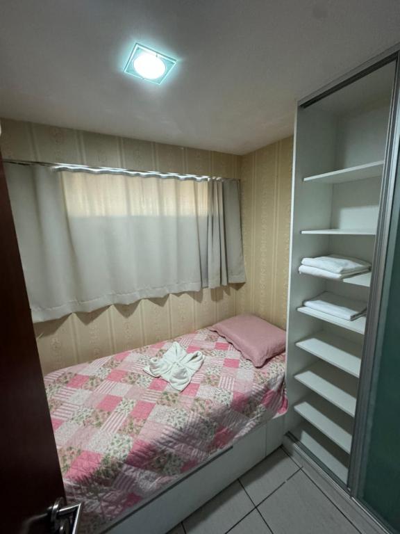 a small bedroom with a bed and a closet at Apartamento Beira Mar Fortaleza Beach Class in Fortaleza